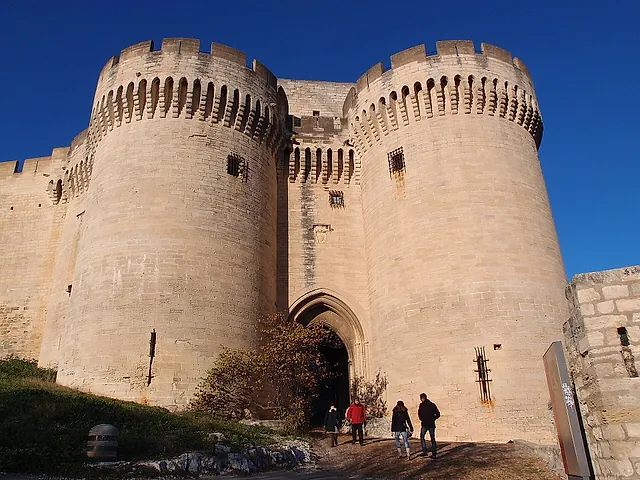 The two round crenellated towers at the gate of Fort Saint-André in Villeneuve-lès-Avignon, with visitors at the entrance