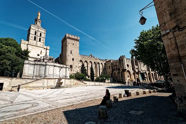 The Place du Palais with the cathedral bell tower and its golden Virgin next to the palace walls, in strong sun