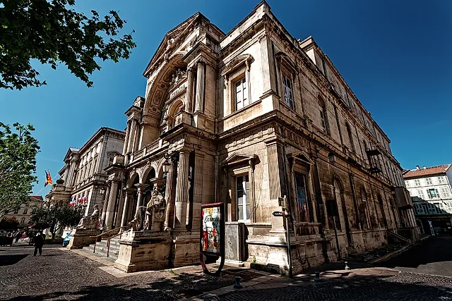 The Opera House on the Place de l'Horloge in Avignon, a carved stone façade under a blue sky