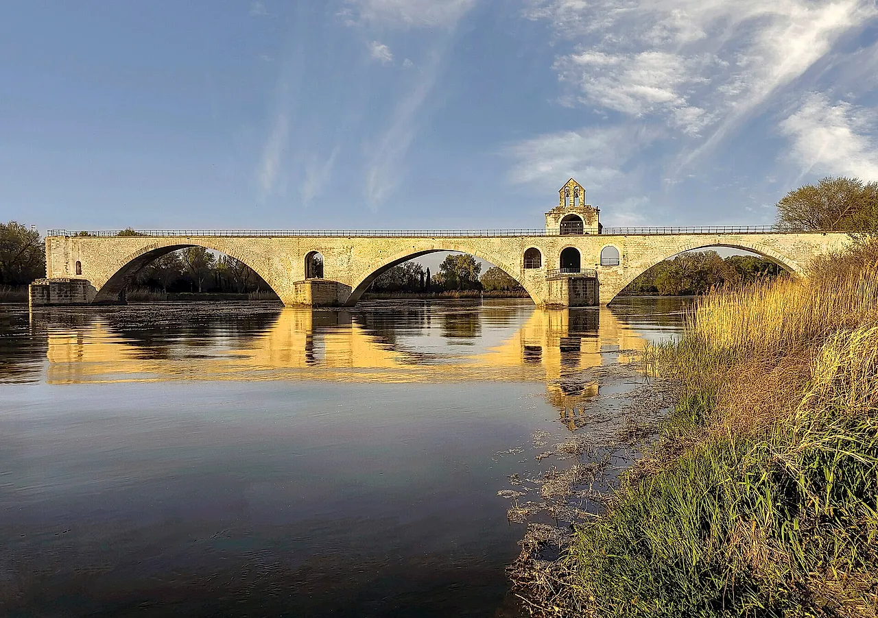 The Pont d'Avignon at golden hour, with the chapel of Saint Nicholas on the bridge reflected in the Rhône