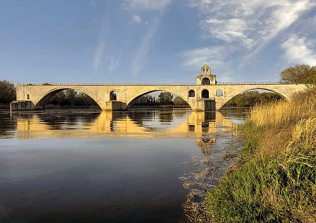The Pont d'Avignon at golden hour, with the chapel of Saint Nicholas on the bridge reflected in the Rhône