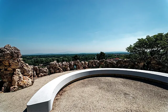 The viewing terrace of the Rocher des Doms, with a curved white bench and the Rhône valley beyond