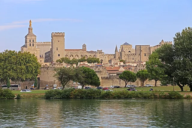 The Palais des Papes and the cathedral rising behind the walls of Avignon, seen across the Rhône